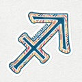 A die-cut sticker featuring the Sagittarius zodiac symbol with a colorful, patterned fill and the word 'SAGITTARIUS' printed along the arrow, shown on a textured off-white background.