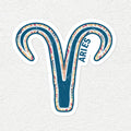A die-cut vinyl sticker of the Aries zodiac symbol, featuring a teal blue and white patterned ram's head with the word 'ARIES' printed vertically, shown on a textured off-white background.