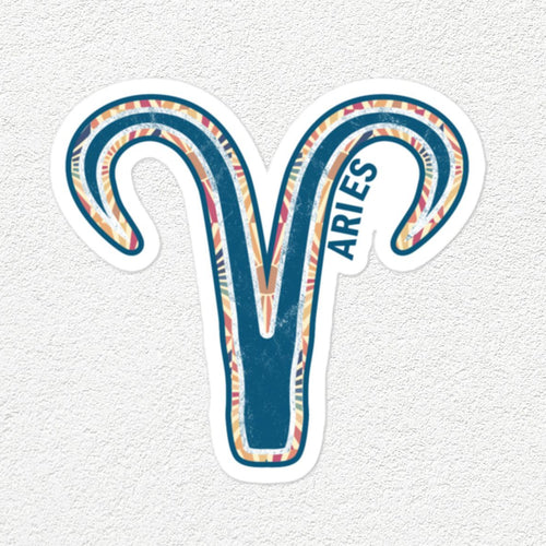 A die-cut vinyl sticker of the Aries zodiac symbol, featuring a teal blue and white patterned ram's head with the word 'ARIES' printed vertically, shown on a textured off-white background.
