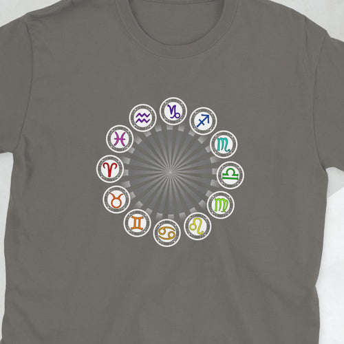 Green t-shirt with colorful zodiac signs on a light gray surface with accessories.
