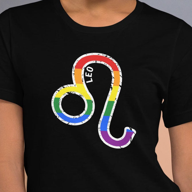Woman wearing a black t-shirt with rainbow Leo astrology zodiac symbol against wall