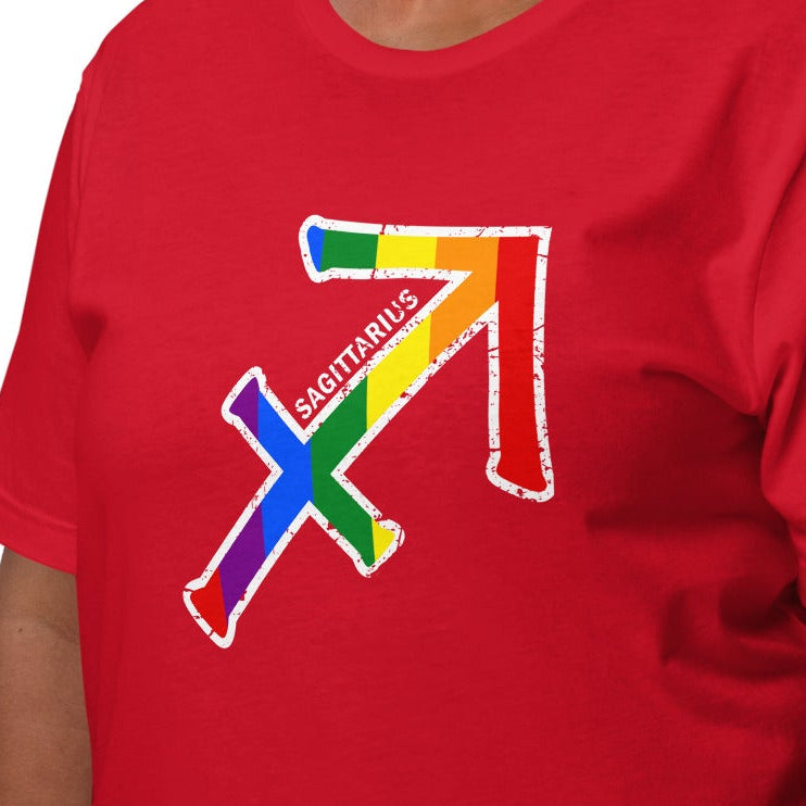 A smiling woman wearing a red short-sleeve t-shirt with a colorful, rainbow-striped arrow Sagittarius graphic on the chest, set against a plain white background.